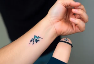 A pair of minimalist black and blue mountain peaks, one tattooed on the father’s forearm and the matching smaller version on the child’s wrist. tattoo idea