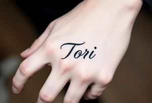 Hand tattoo with the name Tori on a man’s hand tattoo idea