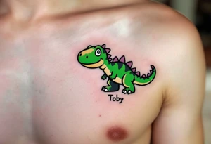 A tiny dinosaur in green and grey, with the son’s nickname Toby written in playful bold font beneath. tattoo idea