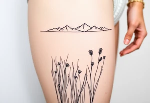 A field with long grass and flowers with mountains in the background tattoo idea