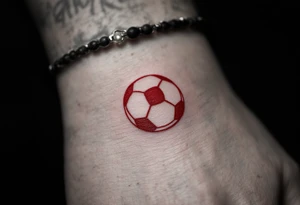 A simple red soccer ball icon on the wrist for a subtle, bold statement. tattoo idea