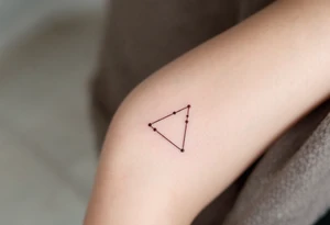 Three copper-toned dots forming an inverted triangle near the base of the thumb, signifying feminine energy and creativity. tattoo idea