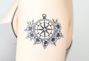 Compass surrounded with flowers cursive letters tattoo idea