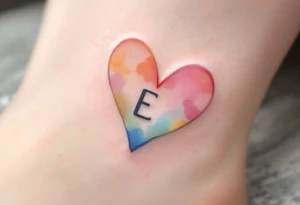 A soft pastel heart outline with a handwritten letter "E" in light grey ink, creating a delicate and airy aesthetic. tattoo idea