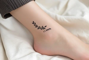 Tiny I.V.MCML on the ankle in black, paired with grayscale olive branches extending around the leg tattoo idea