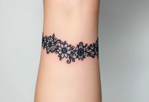 A delicate black lace band wrapped around the wrist, featuring intricate floral and filigree patterns tattoo idea