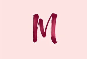 A brush-style "M" in burgundy red, looking bold and spontaneous. tattoo idea