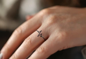 A minimalist black titanium band with a subtle engraved heartbeat line, capturing the rhythm of love. tattoo idea