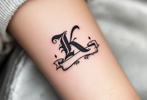 Old English K in matte black, resting on a scroll banner with gray shading, reminiscent of medieval heraldry. tattoo idea