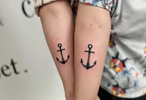 Matching man and woman tiny black anchor tattoos, the father’s on the upper arm tattoo idea