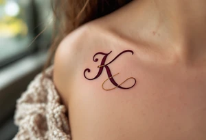 Elegant serif K in deep burgundy, with a gold ribbon woven through the letter's arms. tattoo idea