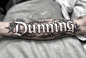 Dunning, left forearm details include angel wing, greek type of font,jungle leaves, name is big and in white color tattoo idea