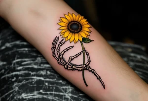 A skeleton hand holding a dying yellow sunflower, quote "memento mori" in thin, winding black cursive along the stem. tattoo idea