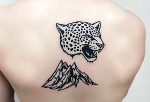 Jaguar face in the back of the arm close to elbow mountains at the bottom close to the wrist tattoo idea