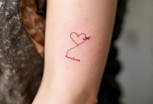 A dotted-line heart in red ink with a tiny plane drawing a trail spelling Karolína. tattoo idea