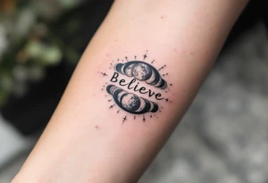The word "Believe" in gray, with moon phases in the background, conveying the cyclical nature of life and faith in change. tattoo idea