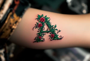 A floral "A" made of intertwined vines and roses in green and burgundy. tattoo idea