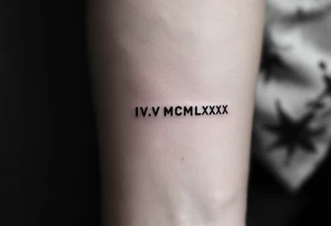 Minimalist IV.V.MCMLXXX tattooed in fine-line black ink on the inner forearm for a birthdate tribute. tattoo idea