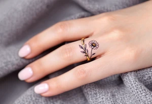 A band around finger with a single engraved daisy tattoo idea