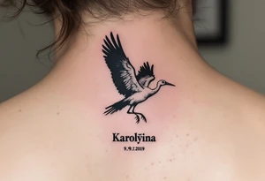 Stork silhouette flying above name Karolína  and numbers "9.9.2019 v 14:10", inked in subtle muted tones. tattoo idea