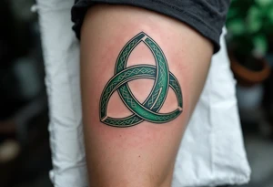 A bold Celtic triskeles  in deep emerald green, with intricate knotwork woven into each spiral, symbolizing eternal growth and balance. tattoo idea