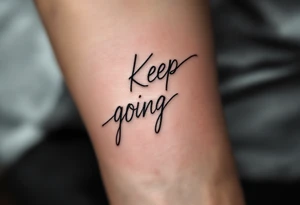 “Keep going” in sleek gray cursive, underlined with a cool blue wave. tattoo idea