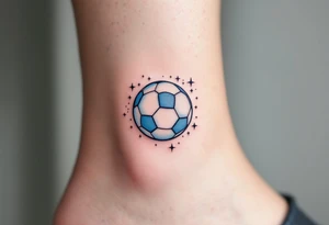 A small ankle tattoo of a pastel blue soccer ball with sparkles around it for a playful look. tattoo idea