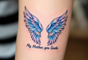 A pair of angel wings in light blue and lavender with “My Mother, My Guide” between them. tattoo idea