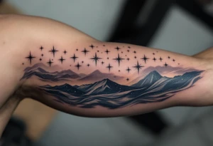 This tattoo combines “Through hardships to the stars” with silver star trails over a midnight blue sky on the upper arm. tattoo idea