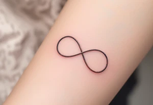 A simple gray infinity outline encircling a small rose-gold heart. tattoo idea