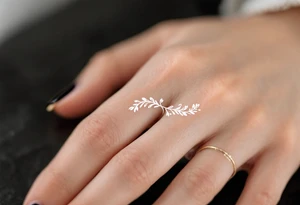 A thin, delicate gold ring tattoo with intricate white filigree engravings, symbolizing timeless elegance and devotion. tattoo idea