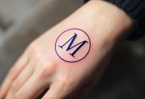 An elegant serif "M" in midnight blue, placed within a fine circular frame. tattoo idea