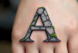 A cracked stone "A" in granite gray with mossy green details. tattoo idea