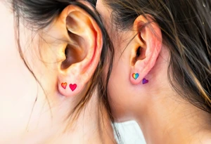Tiny matching rainbow hearts behind ear of each partner to honor love in every shade. tattoo idea