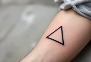 A minimalist black triangle pointing upward, symbolizing stability and strength tattoo idea