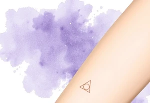 A delicate Deathly Hallows full symbol in thin gold lines, set against a soft watercolor galaxy background in shades of deep purple and midnight blue tattoo idea