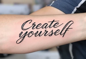 “Create yourself” in graphite black script, with geometric shapes building from the letters in cool grays tattoo idea