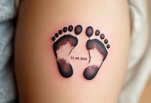 Baby footprints in black ink with the child’s birth date 15. 08. 2018 in soft blue or pink beneath commemorate a mother’s most treasured moment. tattoo idea