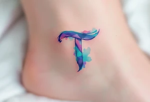 A watercolor-style "T" in shades of turquoise and purple, blending like paint strokes. tattoo idea