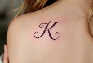 Elegant serif K in deep burgundy, with a gold ribbon woven through the letter's arms. tattoo idea
