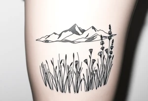 A field with long grass and flowers with mountains in the background tattoo idea