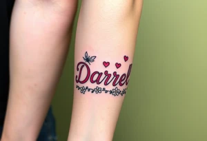"Darrell" in 1 in cute font, inner forearm from elbow to wrist, whimsical, bright neon colors, surrounded with hearts, flowers and fairies tattoo idea
