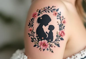 A silhouette of a mother and child in black ink encircled by a floral wreath in pastel hues represents nurturing and tenderness. tattoo idea