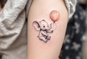 Delicate outline of a baby elephant holding a balloon with name Natálie – 22.10.2023 v 5:15 in pastel peach script. tattoo idea