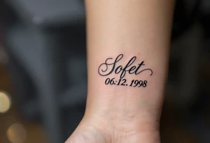 Soft 06.12.1998 in gray cursive with pale lilac linework forming a ribbon below it. tattoo idea