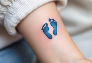 A pair of tiny blue footprints with the son's name in elegant black script beneath. tattoo idea