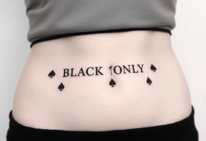 text reading "BLACK ONLY" across a womb tattoo decorated with spades tattoo idea