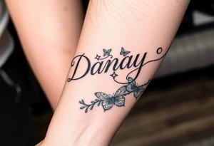 the name Danay, with a background other cool designs that fills up the whole forearm tattoo idea