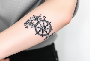 Compass surrounded with flowers cursive letters tattoo idea
