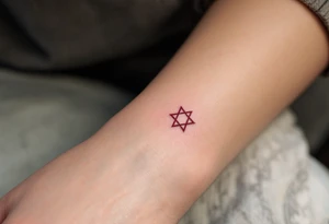 A circle of protective Hebrew letters in deep crimson, enclosing a radiant white star. tattoo idea